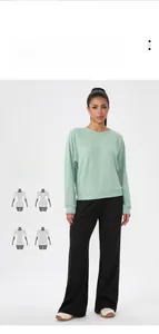 Détail du haut à manches longues gaufré vert menthe avec un pantalon noir large