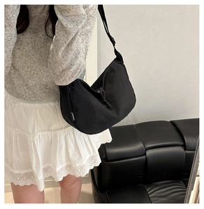Detail of black nylon crescent bag with adjustable wide strap and zipper closure