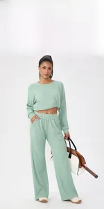 Détail du tissu gaufré vert clair sur le haut de sport et le pantalon assorti