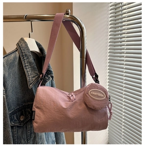 Detailopname van een lavendelkleurige nylon dumplingtas met bijpassende kleine beurs