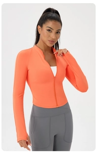 Detail view of orange sports jacket showing stand-up collar and thumbhole cuffs