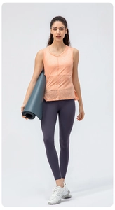 Dettaglio della canotta yoga arancione chiaro e leggings sportivi viola a vita alta