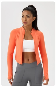 Detail of orange slim fit yoga jacket featuring thumb holes and high-neck zipper closure