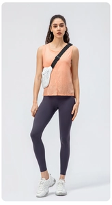 Canotta yoga corallo traspirante con leggings viola e borsa sportiva a tracolla bianca
