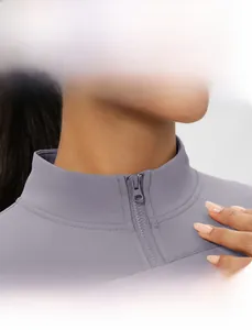 Dettaglio del colletto antivento e della cerniera sulla giacca da yoga color lilla