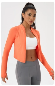 Close-up of bright orange yoga jacket with high neck zipper and thumbhole cuffs