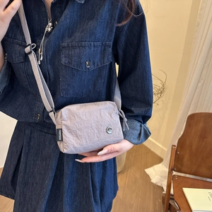 Minimalist light purple nylon crossbody bag with adjustable strap and M logo