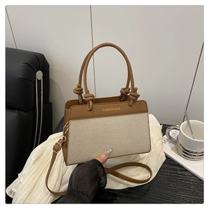 Detailed shot of beige canvas tote with brown leather trim and Fashion Bag gold logo