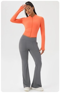 Detail of zip-up yoga jacket with thumbholes and criss-cross high waist flared pants