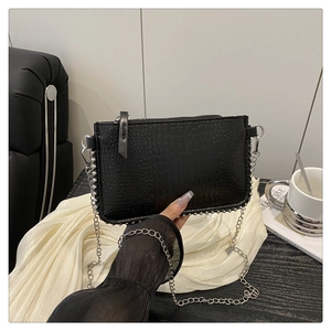 Détail du petit sac noir à motif crocodile avec bordure en perles argentées et lanière