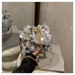Close-up of silver sequins bucket bag with gold chain and large pearl drawstring detail