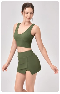 Détail du débardeur de yoga en maille côtelée vert foncé et de la jupe de sport assortie