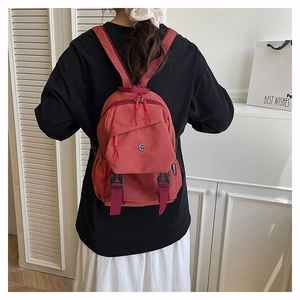 Rear view of a model wearing the red mini nylon backpack with black straps and zippers