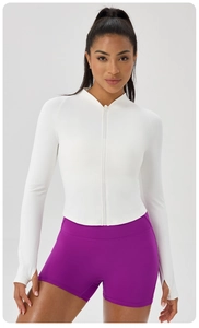 Detail of white slim-fit yoga jacket with zipper collar and purple high-waist sports shorts