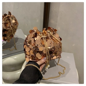 Close-up of rose gold sequin bucket bag with pearl drawstring and golden chain strap
