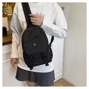 Détail du sac bandoulière en nylon noir avec poches zippées et étiquette mode