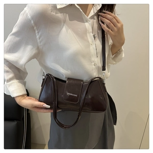 Detail of dark brown patent leather underarm bag with white CAICHENJIABAG logo lettering
