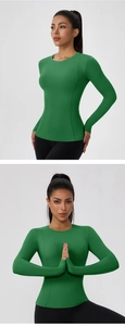 Detail view of emerald green yoga top featuring thumb holes and high-stretch fabric