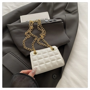 Detail of white quilted crossbody bag featuring gold chain and textured faux leather finish