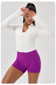 Detail of white slim fit zip jacket with thumb holes and high waist purple shorts