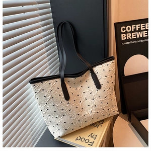 Détail du sac cabas en jacquard crème avec motifs nœuds noirs et texture gaufrée chic