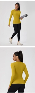Detail view of mustard yellow slim fit long sleeve yoga top with breathable elastic fabric