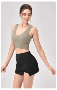 Détail du débardeur de yoga côtelé vert olive et de la jupe de tennis noire à fente latérale