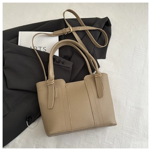 Detailed macro view of khaki lychee grain faux leather texture and metallic buckle strap