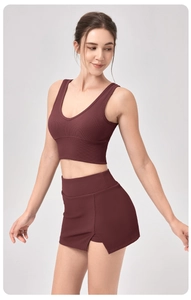 Détail de texture côtelée sur le haut de yoga bordeaux et la jupe-short de sport à taille haute