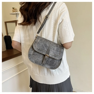 Detailed view of gray retro saddle bag with adjustable strap and vintage buckle