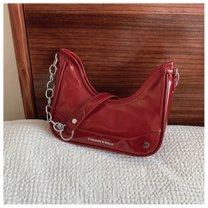 Détail du sac lune en cuir verni rouge avec chaîne argentée et logo texte blanc tendance