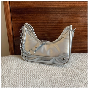 Détail du sac hobo argenté avec texture métallisée, bandoulière chaîne et lettrage gravé