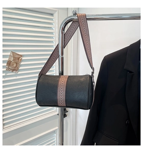 Detail der schwarzen Zylindertasche aus Leder mit gewebtem breitem Schultergurt