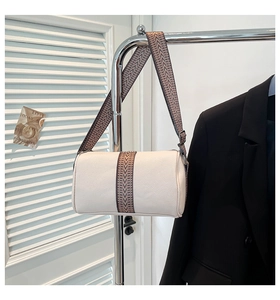 Nahaufnahme der cremefarbenen Zylindertasche aus strukturiertem Kunstleder mit breitem Gurt