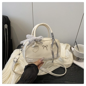 Détail du sac bowling blanc crème en cuir PU avec nœud en dentelle et accent en métal
