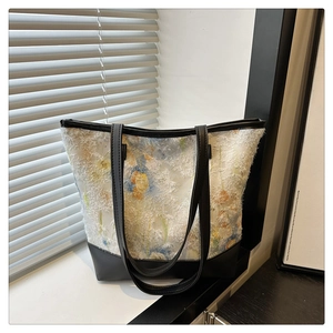 Detail of floral chiffon tote with textured fringe and contrasting black straps