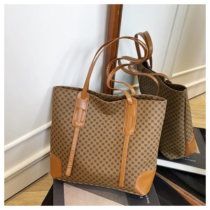 Détail du grand sac cabas monogramme en cuir marron reflété dans un miroir