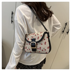 Detailed view of the woven canvas texture with cherry print and golden metal buckle