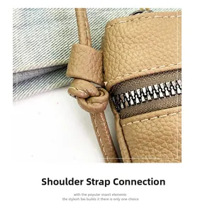 Detail of khaki pebbled leather bag featuring knotted strap design and metallic zipper