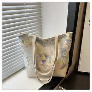 Close-up of floral jacquard texture and cream leather stitching on chic tote bag