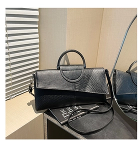 Dettaglio della borsa in PU nero con contrasto tra texture liscia e pelle di serpente