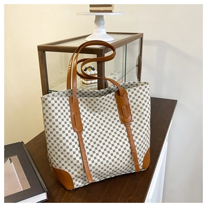 Vue détaillée d'un grand sac fourre-tout à motifs avec des poignées en cuir marron
