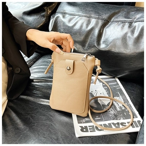 Detail of beige lychee leather phone bag with metal snap button and zipper compartment
