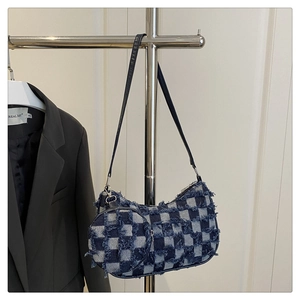 Detail of blue checkerboard crescent bag with frayed edges and matching round coin purse