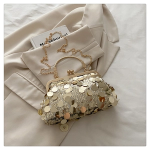 Detail of a gold sequin evening clutch bag with metallic handle and chain strap