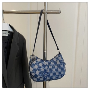 Detail of blue checkerboard denim crescent bag with fringe edges and mini coin purse