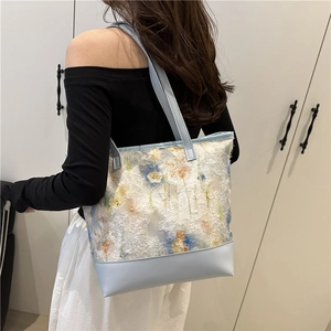 Chic light blue tote bag with white floral lace overlay and leather patchwork base