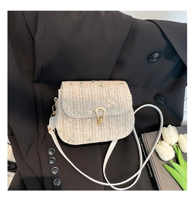 Vue détaillée du sac besace en paille avec broderie florale et fermoir doré en U