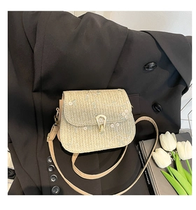 Gros plan du sac en paille tressée beige avec broderie florale et fermoir doré