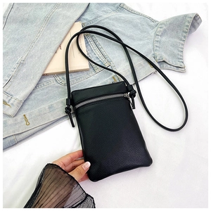 Detail of black pebbled leather phone pouch with silver zipper and slim strap